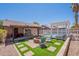 Inviting backyard featuring a pool, fire pit, pergola and an artificial turf area for outdoor relaxation and entertainment at 11252 E Edgewood Ave, Mesa, AZ 85208