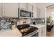 Close up of kitchen area with stainless steel appliances and beautiful tile backsplash at 11252 E Edgewood Ave, Mesa, AZ 85208