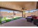 Inviting covered patio featuring a fire pit, seating, and well-maintained artificial turf at 11252 E Edgewood Ave, Mesa, AZ 85208