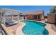 Sparkling pool area featuring a unique pool design, lounge chairs, and a pergola for shaded relaxation at 11252 E Edgewood Ave, Mesa, AZ 85208