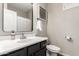 Cozy bathroom featuring a black vanity with a white countertop, framed mirror, and a toilet at 1134 S Lydia Ln, Gilbert, AZ 85296