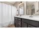 Bathroom featuring a double sink vanity, framed mirrors, and a shower-tub combination with curtain at 1134 S Lydia Ln, Gilbert, AZ 85296