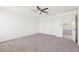 Spacious bedroom with neutral carpet, a ceiling fan, and an ensuite bathroom at 12531 W Glenn Dr, Glendale, AZ 85307