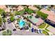 High angle of a bright community pool and tennis court framed by mature trees, landscaping, and resident parking at 1287 N Alma School Rd # 171, Chandler, AZ 85224