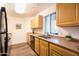 Galley kitchen with wood cabinets and stainless steel sink at 1287 N Alma School Rd # 171, Chandler, AZ 85224