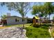 Backyard with artificial turf, patio, and a playground, complemented by the home's exterior at 1311 W Ellis St, Mesa, AZ 85201