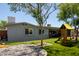 Backyard with artificial turf, patio, and a playground, complemented by the home's exterior at 1311 W Ellis St, Mesa, AZ 85201