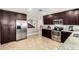 Large kitchen with stainless steel appliances, dark wood cabinets, and granite countertops at 1311 W Ellis St, Mesa, AZ 85201