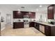 Spacious kitchen boasts dark wood cabinets, granite countertops, and stainless steel appliances at 1311 W Ellis St, Mesa, AZ 85201
