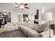 Cozy living room features a large sectional, ceiling fan, and open flow into the kitchen at 1311 W Ellis St, Mesa, AZ 85201