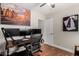 Well-lit home office with modern computer setup, hardwood floors, ceiling fan, and city-themed wall art at 1311 W Ellis St, Mesa, AZ 85201