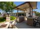 Inviting outdoor kitchen features a granite countertop, built-in grill, and covered seating area for entertaining at 1311 W Ellis St, Mesa, AZ 85201