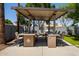 This outdoor kitchen features granite countertops, a built-in grill, and seating, perfect for entertaining guests at 1311 W Ellis St, Mesa, AZ 85201