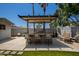 Covered outdoor kitchen has granite countertops, a built-in grill, seating, and heater for year-round enjoyment at 1311 W Ellis St, Mesa, AZ 85201