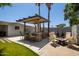 The outdoor kitchen provides granite countertops, a built-in grill, seating, and a cozy fire pit area at 1311 W Ellis St, Mesa, AZ 85201