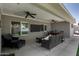 Covered patio featuring stylish wicker furniture, ceiling fans, and a mounted television for outdoor enjoyment at 1311 W Ellis St, Mesa, AZ 85201