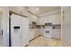 Well-lit kitchen featuring modern white appliances, light wood flooring, and coordinated backsplash tiles at 16537 N Oachs Dr, Surprise, AZ 85374
