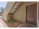 Apartment exterior featuring a brown front door, beige walls, stairs, and decorative rock garden at 1825 W Ray Rd # 1070, Chandler, AZ 85224