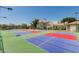 View of a well-maintained tennis court with colorful playing surfaces and surrounding landscaping at 1825 W Ray Rd # 1070, Chandler, AZ 85224