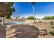 An outdoor backyard with pool, block fence, and green trees at 1906 N Evergreen St, Chandler, AZ 85225