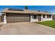 Single-story home featuring a two-car garage, solar panels, and a well-maintained lawn at 1906 N Evergreen St, Chandler, AZ 85225
