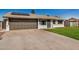 Single-story home featuring a two-car garage, solar panels, and a well-maintained lawn at 1906 N Evergreen St, Chandler, AZ 85225