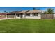 Charming single-story home with a well-manicured lawn and a two-car garage, complemented by solar panels at 1906 N Evergreen St, Chandler, AZ 85225