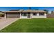 Charming single-story home with a well-manicured lawn and a two-car garage, complemented by solar panels at 1906 N Evergreen St, Chandler, AZ 85225