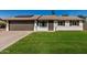 Charming single-story home with a well-manicured lawn and a two-car garage, complemented by solar panels at 1906 N Evergreen St, Chandler, AZ 85225
