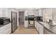 Modern kitchen featuring stainless steel appliances, white cabinets, and tile floors at 1914 S Brooks Cir, Mesa, AZ 85202