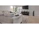 Comfortable living room with tile floors, a neutral sofa, TV, and natural light streaming in through the windows at 1914 S Brooks Cir, Mesa, AZ 85202