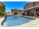 Large swimming pool with a bright blue interior, set in a spacious backyard with lush landscaping at 1914 S Brooks Cir, Mesa, AZ 85202