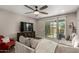 Cozy living area featuring a plush sofa, entertainment center, and sliding glass door to the outdoors at 2023 W Yellowbird Ln, Phoenix, AZ 85085