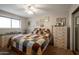 Comfortable bedroom showcasing a cozy bed, neutral walls adorned with artwork, and classic dressers at 2125 E Elmwood St, Mesa, AZ 85213