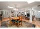 Inviting dining area with a unique table set, skylights, and an open view into the living room and kitchen at 2125 E Elmwood St, Mesa, AZ 85213