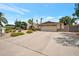 A well-maintained home features a spacious driveway, desert landscaping, and a two-car garage for easy access at 2125 E Elmwood St, Mesa, AZ 85213