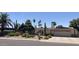 Charming single-story home featuring desert landscaping, an arched entryway, and a two-car garage at 2125 E Elmwood St, Mesa, AZ 85213