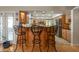 Kitchen bar with granite countertops and barstool seating, opening up to the kitchen with stainless steel appliances at 2125 E Elmwood St, Mesa, AZ 85213