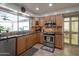 Well-lit kitchen featuring granite countertops, stainless steel appliances, and travertine tile floors for cooking convenience at 2125 E Elmwood St, Mesa, AZ 85213