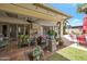 Inviting covered patio with comfortable seating, lush greenery, and views of the sparkling swimming pool at 2125 E Elmwood St, Mesa, AZ 85213