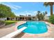 Backyard pool with diving board surrounded by lush landscaping, ideal for outdoor entertaining at 2125 E Elmwood St, Mesa, AZ 85213