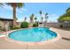 Private backyard pool with diving board, lush landscaping, and a secure perimeter fence at 2125 E Elmwood St, Mesa, AZ 85213