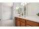 Bathroom with a wood vanity and a bright, large mirror at 21284 E Camacho Rd, Queen Creek, AZ 85142