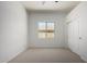 This bedroom offers neutral carpeting, a window, and a closet with sliding doors at 21284 E Camacho Rd, Queen Creek, AZ 85142
