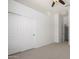 This is a bright bedroom with a ceiling fan, access to an adjacent room, and a spacious closet at 21284 E Camacho Rd, Queen Creek, AZ 85142