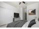 Bright bedroom with a ceiling fan, a closet with double doors, and adjacent bathroom access at 21284 E Camacho Rd, Queen Creek, AZ 85142