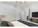 Bright bedroom with a ceiling fan, a closet with double doors, and adjacent bathroom access at 21284 E Camacho Rd, Queen Creek, AZ 85142