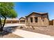 View of front of house showing stucco, desert landscaping, and three-car garage at 21284 E Camacho Rd, Queen Creek, AZ 85142