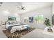Bright bedroom with a ceiling fan, two windows, a bed with blue accents, and a modern bench at 21284 E Camacho Rd, Queen Creek, AZ 85142