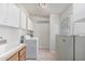 Practical laundry room with white cabinets, tile flooring, sink, and full-size appliances at 2233 E Behrend Dr # 162, Phoenix, AZ 85024